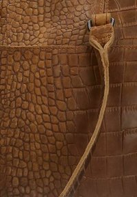Bruine leren handtas met een gestructureerd krokodillenpatroon, voorzien van een lange schouderriem en zilveren hardwareaccenten. Gladde en duurzame afwerking.