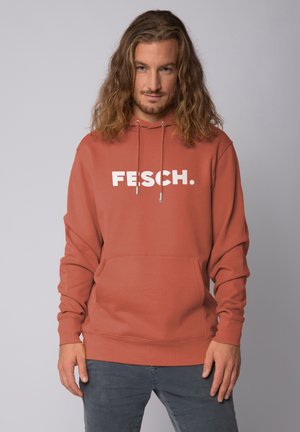 Roestkleurige hoodie van zachte stof, met op de voorkant een groot wit logo "FESCH." en een buidelzak. Verstelbare trekkoordcapuchon.