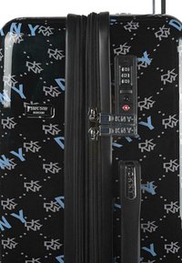 Maleta rígida negra con un patrón de texto "DKNY" en azul y gris. Incluye cierres dobles, un candado de combinación y un asa telescópica.