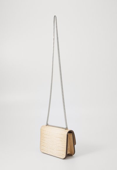 Light beige crocodile-embossed leather handbag with a silver chain strap, rectangular shape, and contrasting dark brown edges.