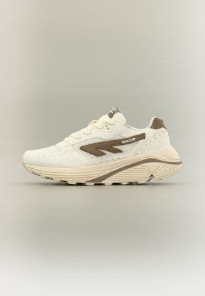 White and beige sneaker with a thick sole, brown side detail, and "SHADOW" text on the side, shown from the outer side.
