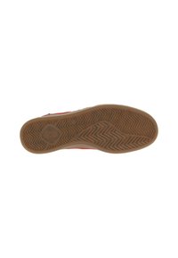 Semelle en caoutchouc marron, présentant un motif de grip en zigzag avec un logo circulaire au centre, et un bord lisse le long des côtés.