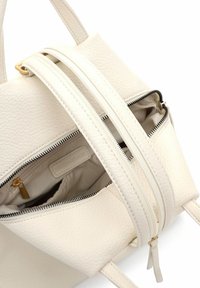 Valge tekstuurse viimistlusega nahast käekott, millel on kaks tõmblukuga taskut, kuldse tooniga riistvara ja reguleeritav rihm mitmekülgseks kandmiseks.