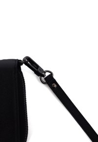 Black leather bag corner with zip and detachable strap. Features a shiny hardware clip and textured surface.