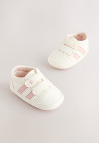 Paire de chaussures blanches pour bébé avec des rayures roses et des détails en forme de cœur, dotée de deux bandes velcro pour une fermeture facile.