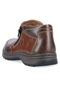 Braune Leder-Stiefelette mit einem Reißverschluss, runder Zehenpartie, genähten Details und einer strukturierten Gummisohle für besseren Halt.