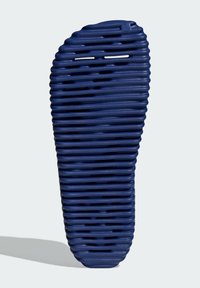 Marinblå texturerad sandalsula med horisontella spår och utskärningar, med rundad tå och en lätt konkav häl för komfort.