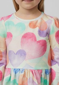 Mehrfarbiges Kleid mit einem Aquarell-Herz-Muster in Pink, Lila und Mint auf einem cremefarbenen Hintergrund, mit einer gerafften Taille und rundem Ausschnitt.