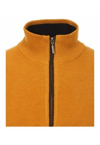 Pomarańczowy sweter z zamkiem błyskawicznym, z wysokim kołnierzem, z ciemnym zamkiem i teksturowanym wzorem na całej powierzchni. Miękka, średniej wagi tkanina.