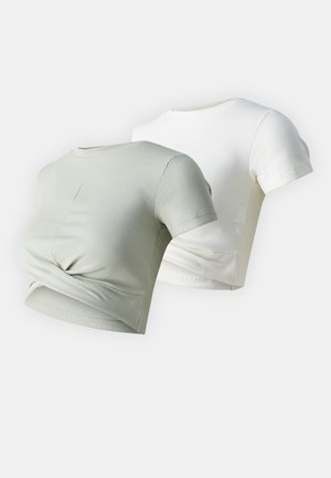 Due magliette corte: una in verde chiaro e l'altra in bianco. Entrambe presentano una texture a coste e un dettaglio anteriore annodato.