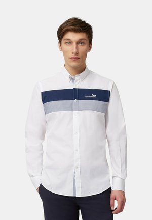Camicia bianca con bottoni dotata di un pannello orizzontale blu navy con strisce e logo. Colletto strutturato e maniche lunghe.
