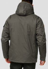 Men's hooded jacket in dark gray, made from a textured fabric. Features a simple design with side pockets and a reinforced hood.
