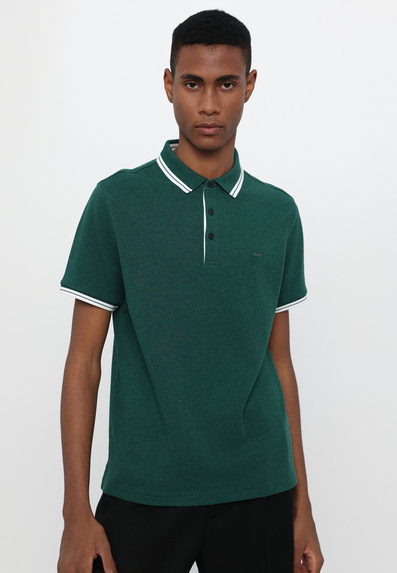 Dunkelgrünes Poloshirt mit weißem Streifenkragen und -bündchen, Knopfleiste, kurzen Ärmeln und einem dezenten Logo auf der Brust.