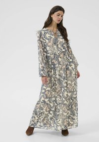 Pikk, kreemjas kleit sinise paisley mustriga, võtmeaugu kaelus ja pikad varrukad. Pehme kangas voolava disaini ja kihilise äärega.