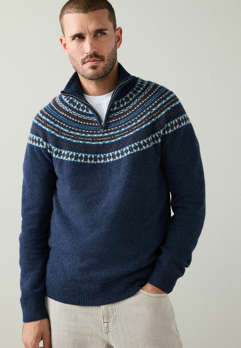Marineblauer Pullover mit Reißverschlusskragen, strukturiertem Stoff und einem gemusterten Passe in Blau, Braun und Weiß. Gerippte Bündchen und Saum.