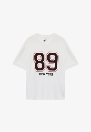 Weißes Kurzarm-T-Shirt mit einem schwarzen "89"-Grafik, umrissen in Rot, und "NEW YORK" in fettem schwarzen Text darunter gedruckt. V-Ausschnitt-Design.