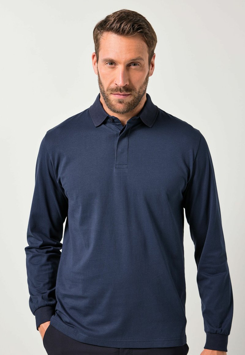 Navy pitkähihaine polo paita, jossa on teksturoitu kangas, klassinen kaulus ja kolmen napin lista. Sisältää ribbikuvioiset hihansuut ja hienovaraisen kuvituksen.