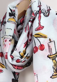 Lichtblauwe sjaal met een patroon van gestileerde illustraties van kersen, cupcakes, kaarsen en kandelaren in rood, geel en zwart. Zachte stoffen textuur.