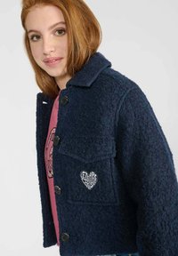 Veste en mélange de laine bleu marine avec une finition texturée, fermeture à boutons, et une poche poitrine orn ée d'une pièce en forme de cœur avec logo.