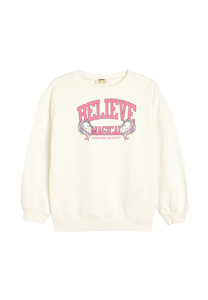 Sweatshirt blanc à col rond, à manches longues. Sur le devant, un graphique en texte rose indique "CROIS EN MAGIQUE" avec des illustrations de licornes. Texture douce.