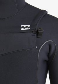 Black wetsuit with a smooth texture, featuring a distinctive logo, front zipper, and adjustable strap detail. Designed for water activities.
