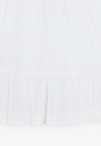 Weißes Baumwollkleid mit bestickten Blumenmustern, Durchbruchdetails und einem gerafften Rüschensaum. Glatte Textur, knielanges Design.