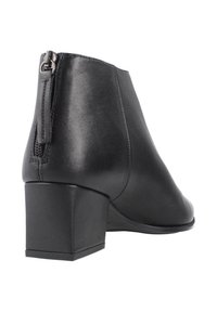 Stivale alla caviglia nero con superficie in pelle liscia, tacco a blocco e zip posteriore per una facile calzata. Il design è minimalista e strutturato.