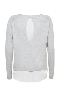 Pull gris à manches longues et col rond, avec une découpe en forme de clef dans le dos. Le tissu semble doux et légèrement texturé.