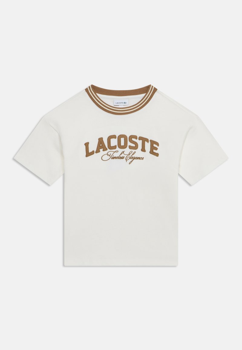 T-shirt blanc à manches courtes avec col rayé marron et texte marron "LACOSTE Timeless Elegance" sur le devant.