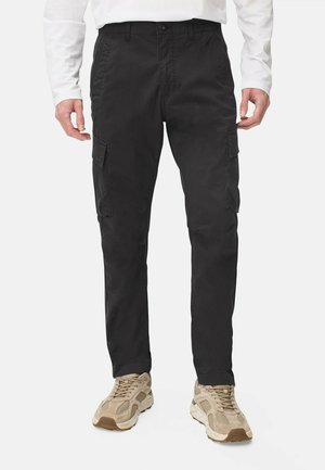 Black cargo pants with front and side pockets, made of lightweight fabric. Straight-cut design, paired with beige athletic shoes.