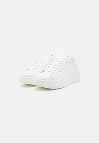 Hvite sneakers med glatt lærfinish, rund tå, flat såle og minimalistisk design; har lisser og subtile merkevare detaljer.