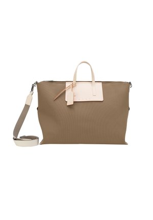 Grande borsa tote taupe con manici crema, tracolla removibile e piccolo portabagagli attaccato, su sfondo bianco.