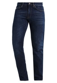 Jeans de mezclilla azul oscuro con corte recto, que presentan un diseño clásico de cinco bolsillos, un ligero desgaste y detalles de botones metálicos.