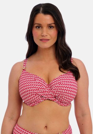 Top de bikini con estampado rojo y blanco, con aros, tirantes anchos y sutiles detalles en dorado. El diseño curvado mejora la forma y el soporte.