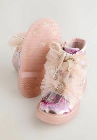 Stivali rosa per bambini con fiori, fiocchi in tulle e charm di strass, dotati di suole testurizzate a forma di stella e fodera interna morbidissima.