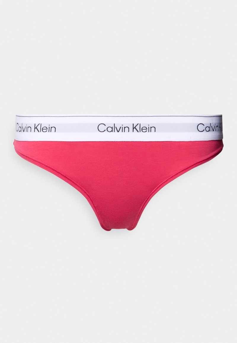 Γυναικείο στρινγκ Calvin Klein σε έντονο ροζ βαμβάκι με λευκή ελαστική ζώνη μέσης που φέρει μαύρο λογότυπο. Ομαλή υφή, τριγωνικό σχήμα.