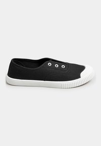 Scarpa slip-on nera in tela con punta e suola in gomma bianca. Presenta tre occhielli metallici per i lacci e una superficie testurizzata.