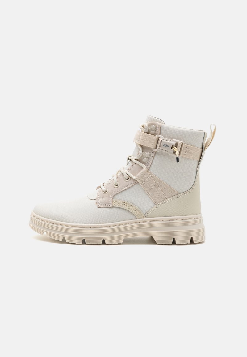Bottes mi-hautes beiges en tissu texturé avec une semelle épaisse et rainurée. Dotées d'un laçage frontal et d'une sangle ajustable avec des accents métalliques.