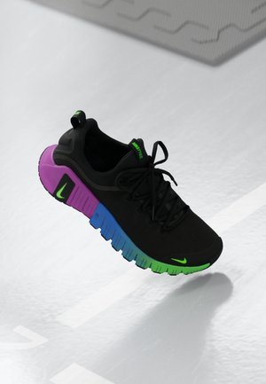 Black athletic shoe featuring a gradient sole of purple, blue, and green, with a sleek design and black laces. Accented with a green logo.
