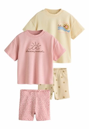 Két gyermek rövid ujjú felső és hozzáillő rövidnadrág; rózsaszín szett nap mintával és „chasing sunsets” szöveggel, krémszínű szett nap grafikával és napmintás rövidnadrággal.