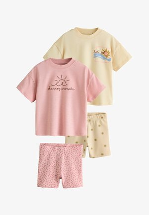 Dos camisetas de manga corta para niños y pantalones cortos a juego; conjunto rosa con sol y texto "chasing sunsets", conjunto crema con gráfico de sol y pantalones cortos con estampado de sol.