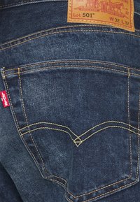 Pantalones vaqueros de mezclilla azul oscuro de Levi's, bolsillo trasero con etiqueta de logo roja y etiqueta de tamaño de cuero marrón W32 L32 Lote 501.
