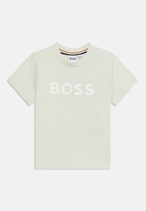 Gaiši zaļa īsroku bērnu T-krekls ar baltu uzrakstu "BOSS" uz krūtīm un divām spiedpogām uz kreisā pleca.