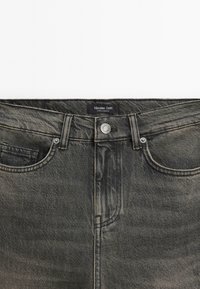 Schwarze Jeans aus Denim mit einem verwitterten Design, ausgestattet mit einem Knopfverschluss, im Five-Pocket-Stil und einem Etikett mit der Aufschrift "Massimo Dutti."