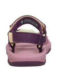Sandalia morada con correas ajustables, plantilla acolchada rosa y suela texturizada para mayor agarre. Adecuada para actividades al aire libre.