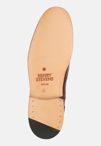 Braune Lederschuh-sohle mit glattem beigen Finish, ausgestattet mit schwarzer Gummiferse und geprägtem Markenlogo "HENRY STEVENS BERLIN."