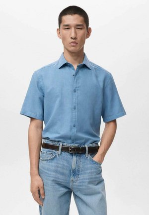 Hellblaues kurzärmeliges Hemd aus einem glatten Stoff, kombiniert mit hellblauen Jeans und einem dunkelbraunen Gürtel. Einfaches, sauberes Design.