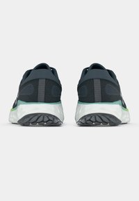 Chaussures de course gris foncé avec une tige texturée, des accents réfléchissants et une semelle intermédiaire amortie. La semelle extérieure présente un motif de bande de roulement antidérapant.