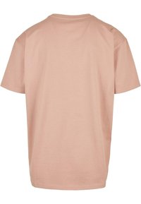 Kortermet rosa t-skjorte med rund hals og avslappet passform, laget av et glatt og mykt stoff med ensfarget design uten synlige mønstre.