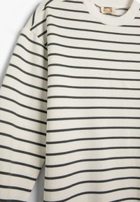 Witte langemouths T-shirt met marineblauwe horizontale strepen, gemaakt van zacht katoen. Kenmerkt een ronde halslijn en een ontspannen pasvorm.